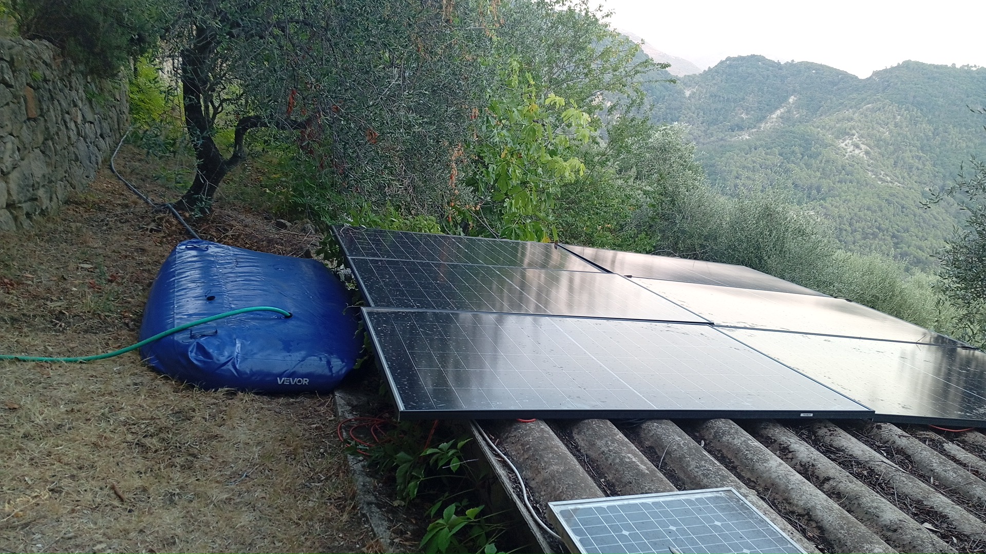 Panneaux solaires et réserve d'eau face aux collines